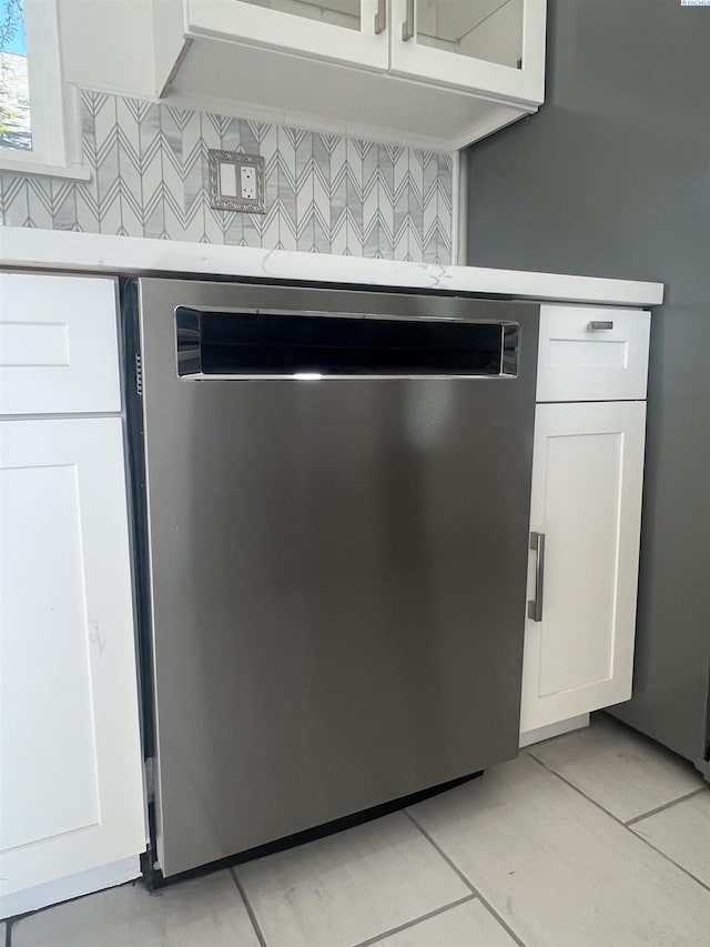 room details featuring light countertops, decorative backsplash, white cabinets, and dishwasher
