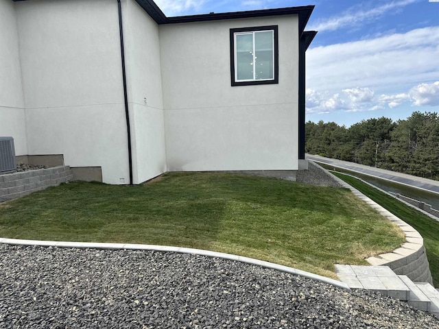 view of side of property with a lawn and stucco siding