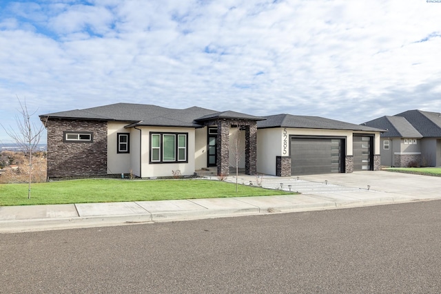 prairie-style house featuring a garage and a front yard