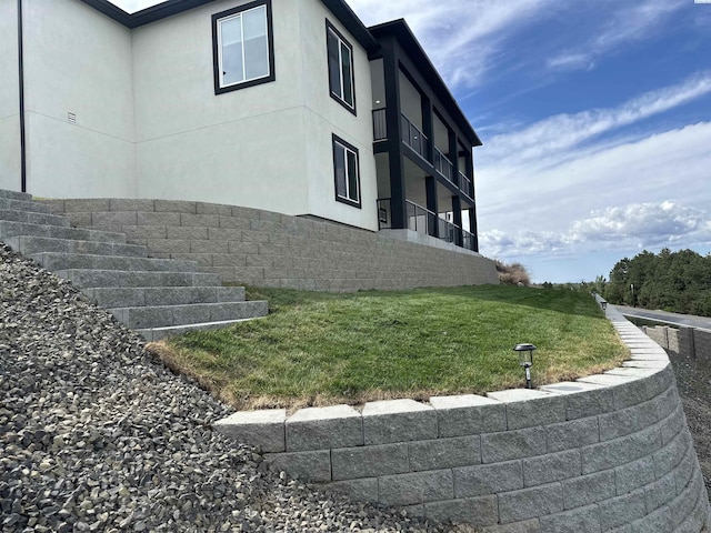 view of property exterior featuring stucco siding and a yard