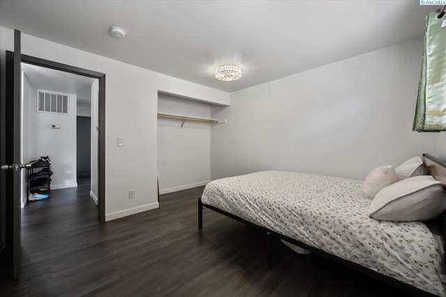 bedroom with baseboards, a closet, dark wood-style flooring, and visible vents