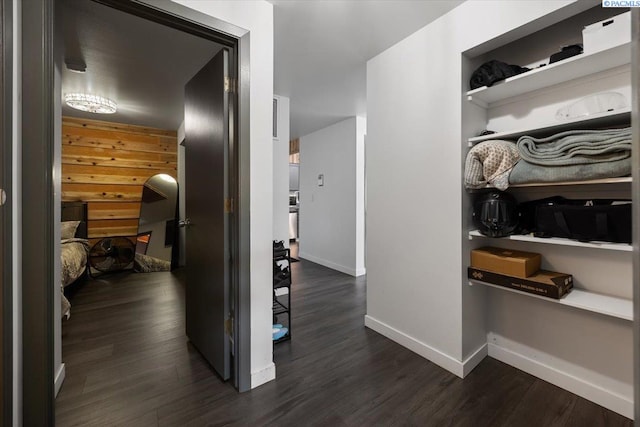 hallway featuring baseboards and dark wood-style flooring