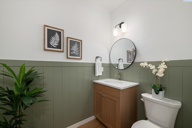 670 Cortona Unit 39, Richland, WA 99352 - half bathroom featuring vanity, toilet, and a wainscoted wall
