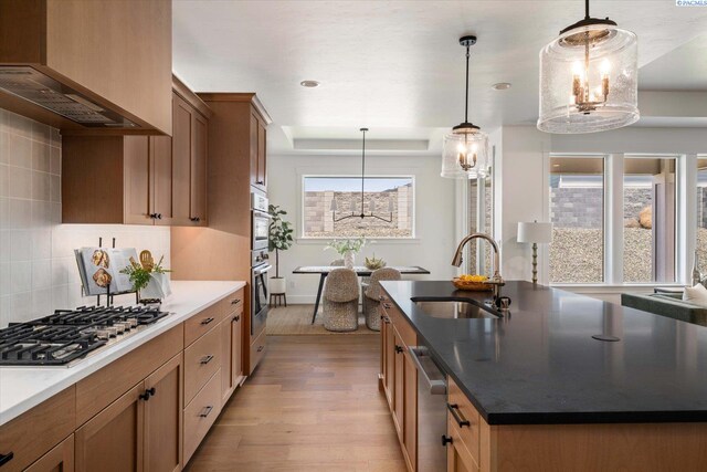 670 Cortona Unit 39, Richland, WA 99352 - kitchen with a sink, appliances with stainless steel finishes, light wood-style floors, decorative backsplash, and a center island with sink