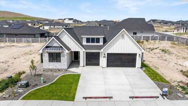 670 Cortona Unit 39, Richland, WA 99352 - view of front of property featuring board and batten siding, a residential view, concrete driveway, roof with shingles, and stone siding