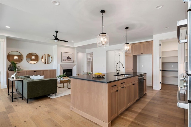 670 Cortona Unit 39, Richland, WA 99352 - kitchen with a sink, dark countertops, ceiling fan, stainless steel dishwasher, and light wood-style flooring