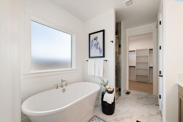 670 Cortona Unit 39, Richland, WA 99352 - full bath with marble finish flooring, a freestanding bath, vanity, a walk in closet, and a stall shower
