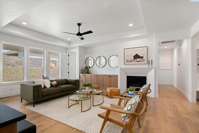 670 Cortona Unit 39, Richland, WA 99352 - living area with a tray ceiling, a ceiling fan, light wood finished floors, baseboards, and a fireplace
