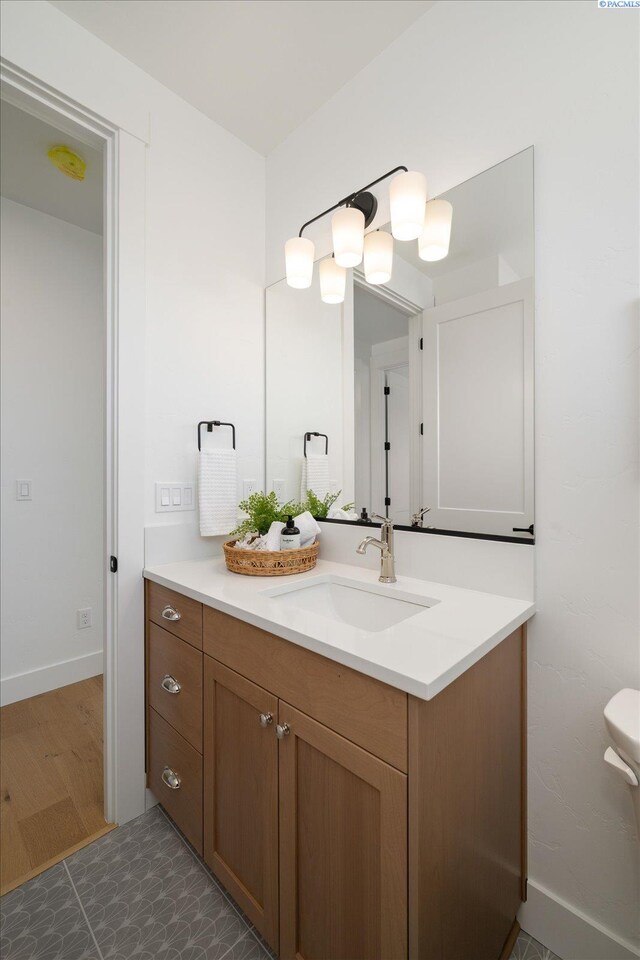 670 Cortona Unit 39, Richland, WA 99352 - bathroom featuring vanity, baseboards, and toilet