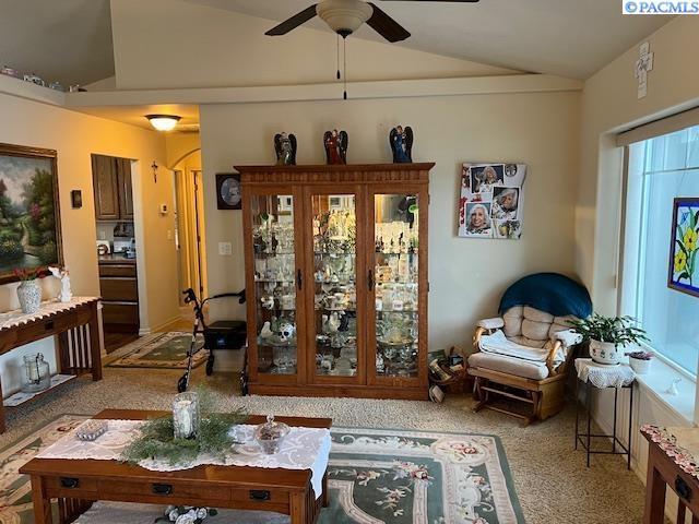 living room featuring lofted ceiling, carpet flooring, and ceiling fan