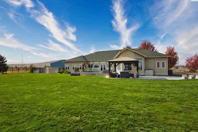 rear view of property featuring a yard, a gazebo, a patio area, and outdoor lounge area