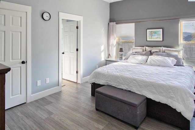 bedroom with light hardwood / wood-style floors and multiple windows