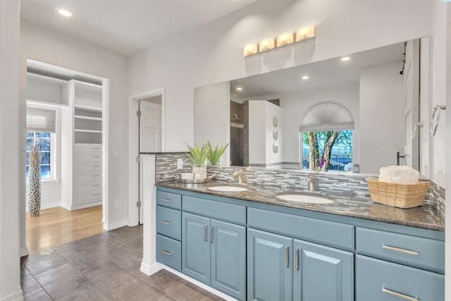 full bathroom featuring tasteful backsplash, a healthy amount of sunlight, and a sink