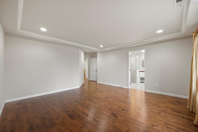 unfurnished room featuring ornamental molding, dark hardwood / wood-style flooring, and a raised ceiling