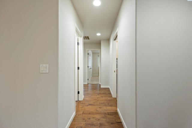 hallway with hardwood / wood-style floors