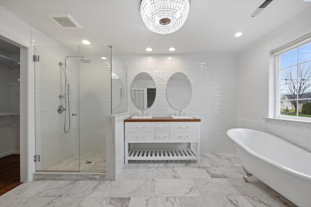 bathroom with tile walls, vanity, and independent shower and bath