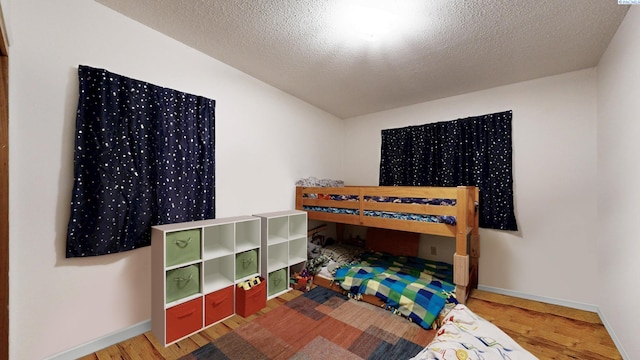 1735 NE Wheatland Dr, Pullman, WA 99163 - bedroom with a textured ceiling, baseboards, and wood finished floors