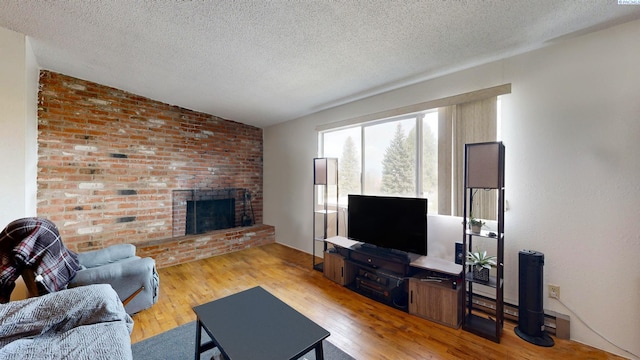 1735 NE Wheatland Dr, Pullman, WA 99163 - living room with a textured ceiling, a brick fireplace, wood finished floors, and vaulted ceiling