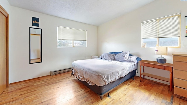 1735 NE Wheatland Dr, Pullman, WA 99163 - bedroom featuring light wood-style flooring, a textured ceiling, and a baseboard radiator