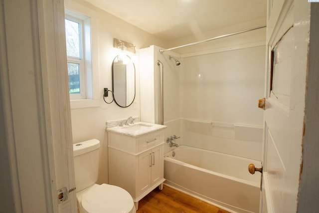 bathroom featuring vanity, bathtub / shower combination, toilet, and wood finished floors