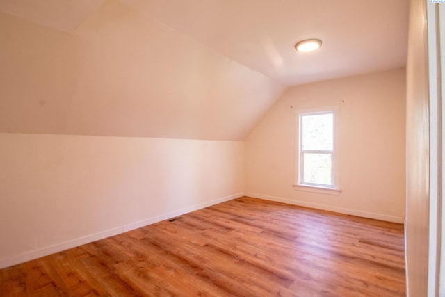 bonus room featuring wood finished floors, baseboards, and lofted ceiling