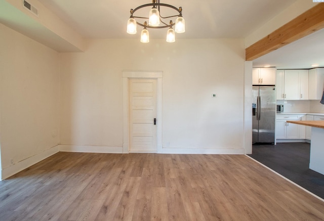interior space with a notable chandelier, light countertops, white cabinets, visible vents, and stainless steel appliances