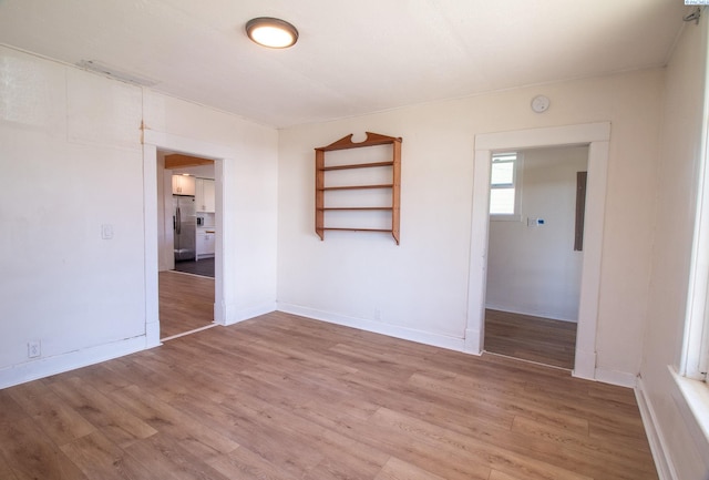 unfurnished room featuring light wood-type flooring and baseboards
