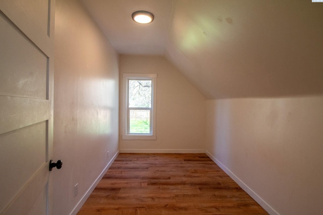 bonus room featuring baseboards, vaulted ceiling, and wood finished floors