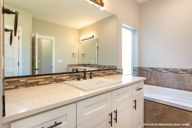 2989 Wild Canyon Way, Richland, WA 99354 - bathroom featuring vanity, tiled bath, and backsplash