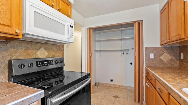 4745 W Robin Ct, West Richland, WA 99353 - kitchen featuring stainless steel electric range oven, white microwave, tile counters, and tasteful backsplash