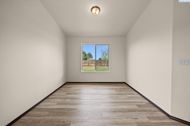 empty room with baseboards and light wood-type flooring