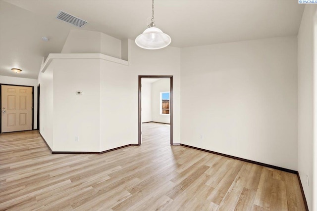spare room with baseboards, visible vents, and light wood-style floors
