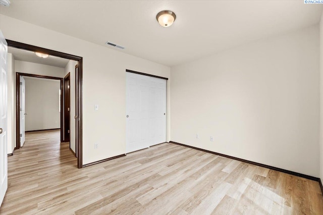 unfurnished bedroom featuring light wood-style floors, baseboards, and visible vents