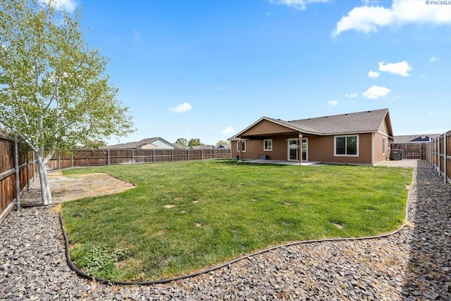 rear view of property featuring a fenced backyard, a patio area, and a yard