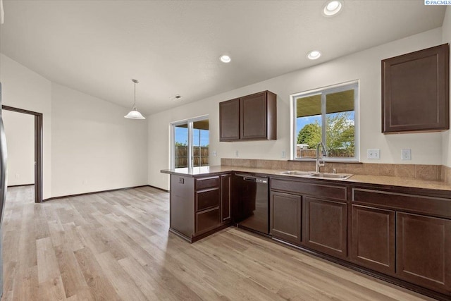 kitchen with dark brown cabinets, a sink, a peninsula, black dishwasher, and light wood-style flooring