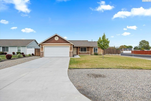 ranch-style house with a garage, fence, a front lawn, concrete driveway, and stone siding