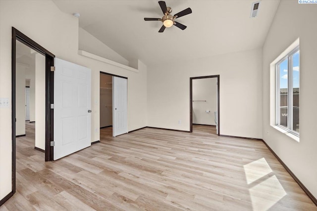 unfurnished bedroom with ceiling fan, light wood-style floors, baseboards, lofted ceiling, and visible vents