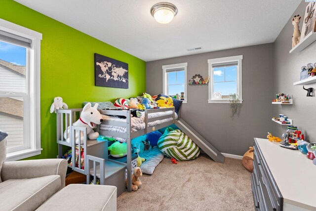 bedroom with baseboards, visible vents, and light colored carpet