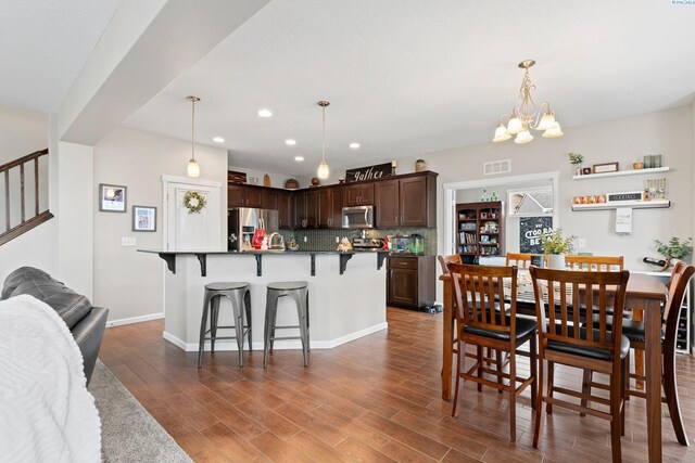 dining space featuring a chandelier, recessed lighting, dark wood-type flooring, visible vents, and baseboards