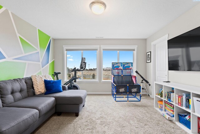 carpeted living area with a textured ceiling and baseboards