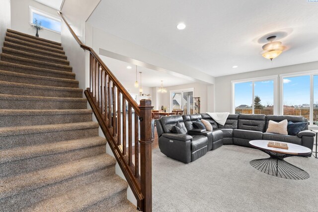 living area featuring recessed lighting, a notable chandelier, stairway, and carpet