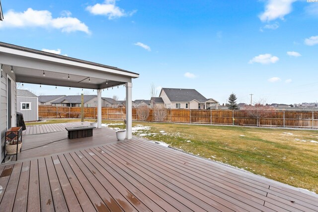 wooden deck with a fenced backyard, a residential view, and a lawn