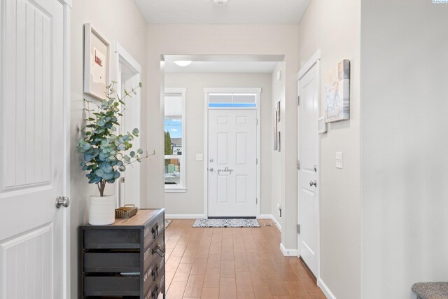 foyer entrance with baseboards and light wood finished floors