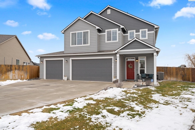 traditional-style home featuring driveway, central AC, an attached garage, and fence