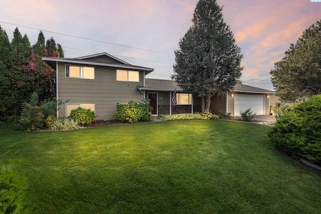 split level home featuring a garage and a lawn