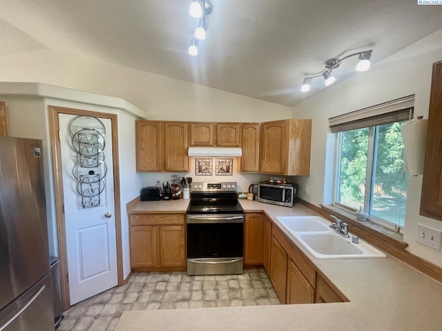 5019 Cambridge Ln, Pasco, WA 99301 - kitchen featuring stainless steel appliances, under cabinet range hood, light countertops, vaulted ceiling, and brown cabinets