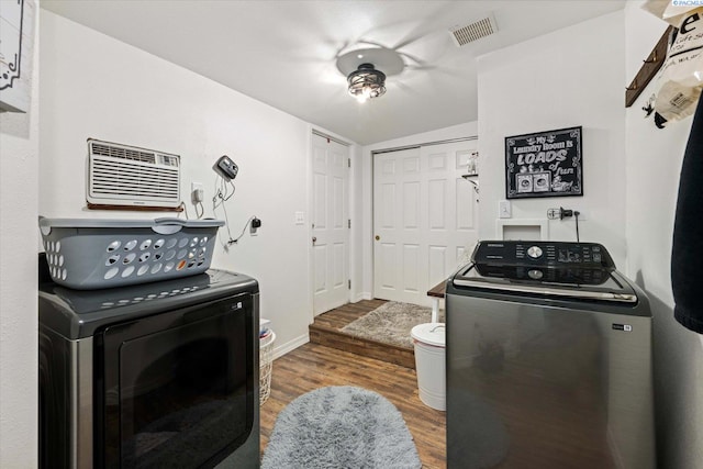 518 Wright Ave, Richland, WA 99352 - laundry room with washing machine and clothes dryer, wood finished floors, an AC wall unit, and baseboards
