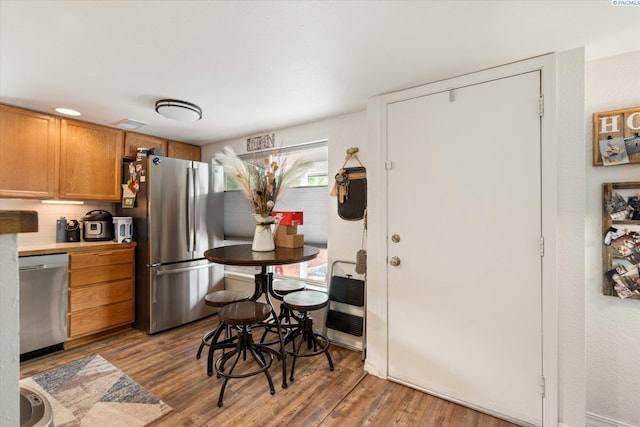 518 Wright Ave, Richland, WA 99352 - kitchen with stainless steel appliances, wood finished floors, brown cabinetry, and light countertops