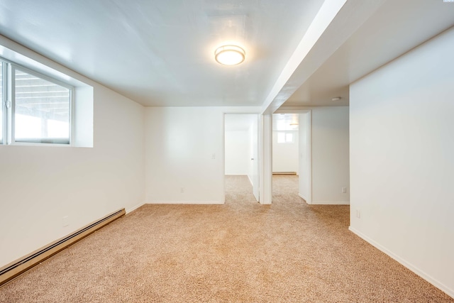 carpeted spare room with baseboard heating and a wealth of natural light