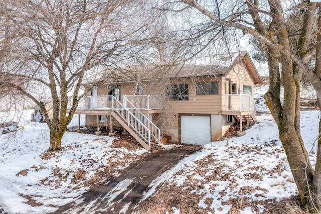 view of front facade with an attached garage, driveway, and stairs